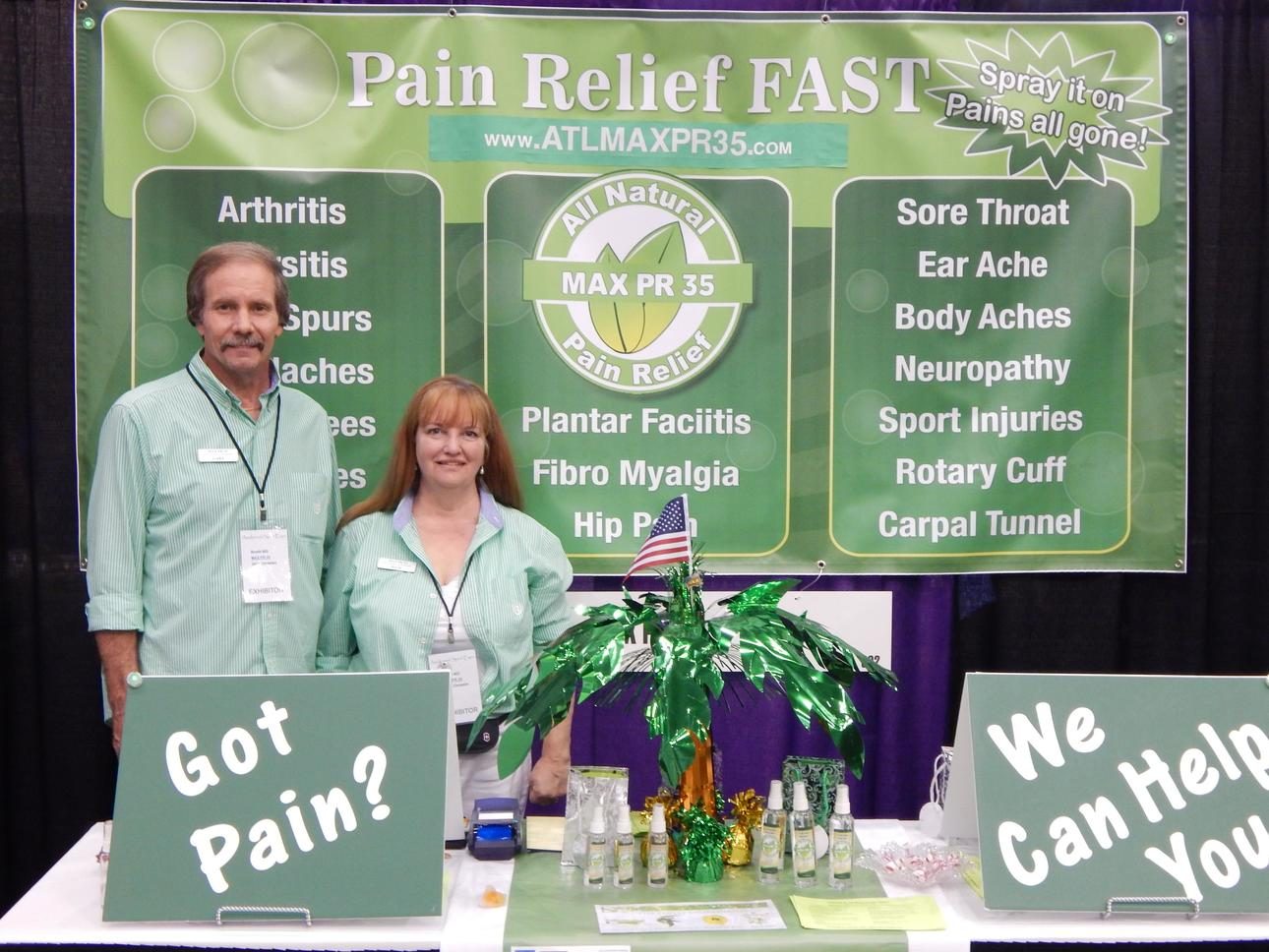 Gary and Julie Christian at their trade show booth with bottles of MaxPR35